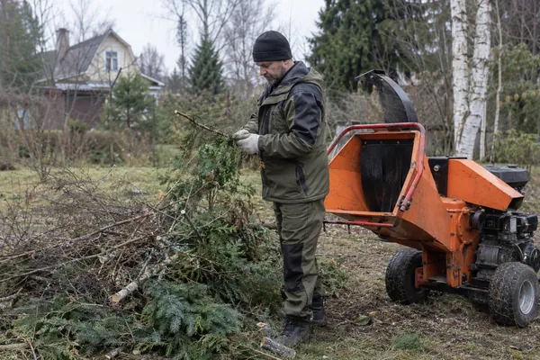 Измельчение веток на участке — подготовка следующей партии. Визуальная концепция работы специалистов.